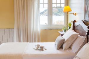 a bedroom with a white bed with a window at La Galería in Donostia-San Sebastián