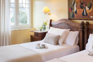 a bedroom with two beds with a tray with a cup of coffee at La Galería in Donostia-San Sebastián