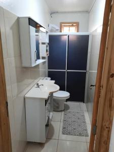 a bathroom with a white sink and a toilet at Casa da Karin in Torres