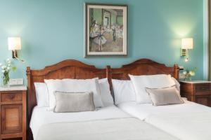 two beds in a bedroom with blue walls at La Galería in Donostia-San Sebastián