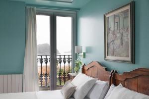 a bedroom with a bed and a window with a balcony at La Galería in Donostia-San Sebastián