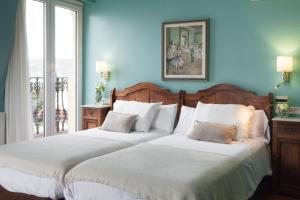 two beds in a room with blue walls at La Galería in Donostia-San Sebastián