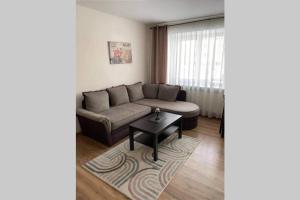 a living room with a couch and a table at Apartamentai Draugystes Street in Šiauliai
