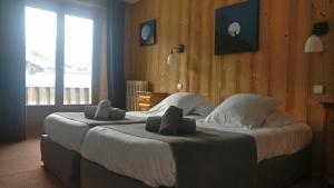 a hotel room with two beds with towels on them at Hôtel Bellier in Val-d'Isère