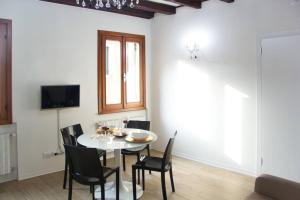 a dining room with a white table and chairs at Ca' Venice Canal View in Venice