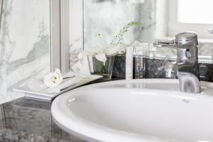 a bathroom sink with a faucet and flowers on a counter at La Galería in Donostia-San Sebastián