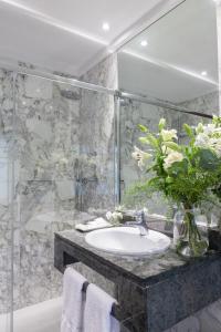 a bathroom with a sink and a vase of flowers at La Galería in Donostia-San Sebastián