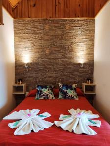 a red bed with two flowers on top of it at Hotel Berlin in Villa General Belgrano