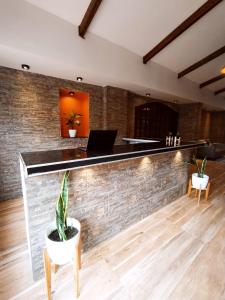 a bar with a laptop on a brick wall at Hotel Berlin by CPH in Villa General Belgrano