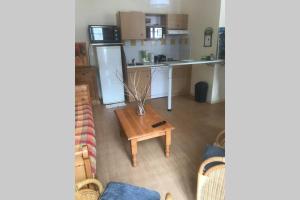 un salon avec une table et une cuisine dans l'établissement T2 "Le Dahu" Résidence Grand Hôtel appt 102 - village thermal montagne, à Aulus-les-Bains