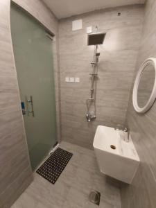 a bathroom with a sink and a shower with a mirror at Reef Al-Hijrah Furnished Apartments in Al Madinah