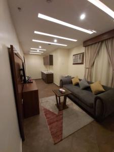 a living room with a couch and a table at Reef Al-Hijrah Furnished Apartments in Al Madinah