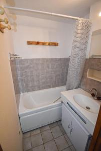 a bathroom with a white tub and a sink at Le Pied des Pistes A13, Joli Studio tout confort 4 pers, vue vallée imprenable, DRAPS NON COMPRIS in Saint-Jean-d'Aulps