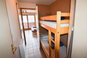 a room with two bunk beds and a hallway at Le Pied des Pistes A13, Joli Studio tout confort 4 pers, vue vallée imprenable, DRAPS NON COMPRIS in Saint-Jean-d'Aulps