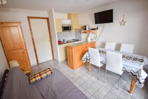une cuisine et une salle à manger avec une table et des chaises dans l'établissement Le Pied des Pistes A13, Joli Studio tout confort 4 pers, vue vallée imprenable, DRAPS NON COMPRIS, à Saint-Jean-dʼAulps 6 autres photos