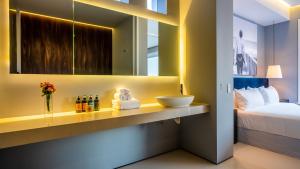 Un baño con lavabo, cama y espejo. en PIER 57 - 509 Unique 2 BR Condo Romantic Zone, en Puerto Vallarta