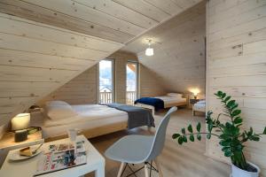 a bedroom with two beds and a table and a chair at Domki Bajeczny Łan in Tylicz +42 photos