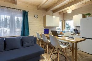 a living room with a table and a blue couch at Domki Bajeczny Łan in Tylicz