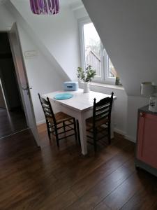 un tavolo bianco con sedie in una stanza con finestra di Haus Alma a Wardenburg