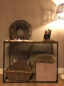 a shelf with two baskets and a lamp on it at Le petit béguinage in Tongeren