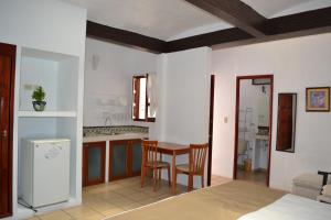 a kitchen with a table, chairs and a refrigerator at Las Mariposas Hotel & Studios in Oaxaca City