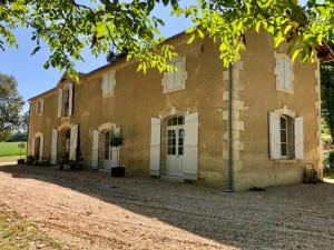 a large brick building with white doors and windows at La Ferme de Saint Christeau in Auch