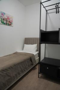 a bedroom with a bed and a black book shelf at Sulu Hostel in Astana