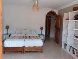a bedroom with a bed and two shelves at ESCALE PARADIS 10 pers 4 ch 3 sdb piscine in Aourir +31 photos