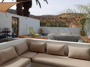 a living room with a couch and a patio with a table at ESCALE PARADIS 10 pers 4 ch 3 sdb piscine in Aourir
