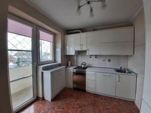 a kitchen with white cabinets and a sink at Двокімнатна квартира біля басейну in Berehove