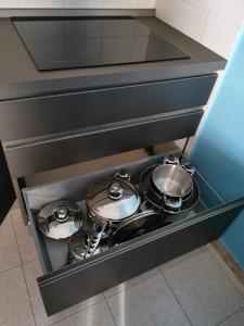 un tiroir avec deux casseroles et des poêles dans la cuisine dans l'établissement Gallipoli lido San giovanni, à Gallipoli
