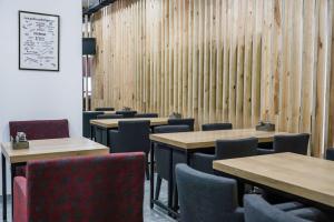 a dining room with tables and chairs and wooden walls at Sulu Hostel in Astana