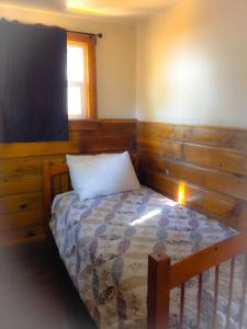 a small bedroom with a bed and a window at Embers Lodge & Cabins in Big Bear Lake