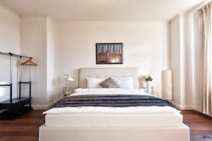 - une chambre blanche avec un grand lit blanc dans l'établissement Central Park Apartments, à Odessa