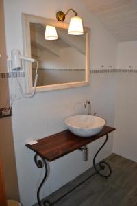 a white sink sitting under a mirror in a bathroom at B&B Residenza Marina in Marina di Carrara