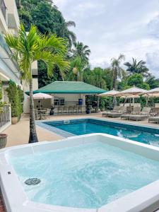 una piscina con una palmera y un edificio en Villa do Vale Boutique Hotel, en Blumenau