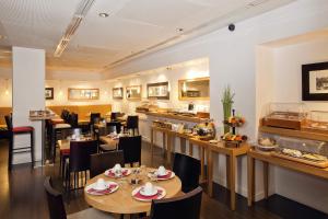 a restaurant with tables and chairs and a bar at Residhome Paris Opéra in Paris