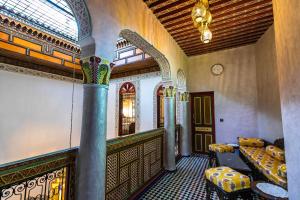 una stanza con un pilastro, un tavolo e una finestra di Dar El Ouedghiri a Fes