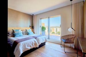 a bedroom with a large bed and a large window at D&R penthouse on the beach in Málaga