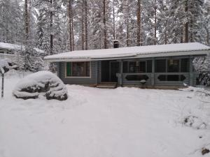 a house covered in snow in the woods at Holiday Cabin Kerimaa 121 in Savonlinna