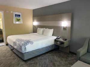 a hotel room with a large bed and a chair at Best Western Apalach Inn in Apalachicola +17 photos