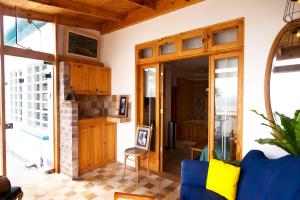 a living room with wooden cabinets and a blue couch at Kauhuhu Casa Hotel in San Bartolo
