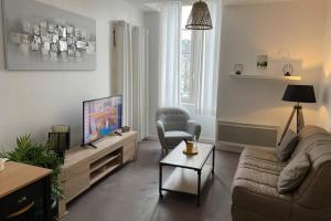 sala de estar con sofá y TV en logement entier 33 m2 à Pau, en Pau