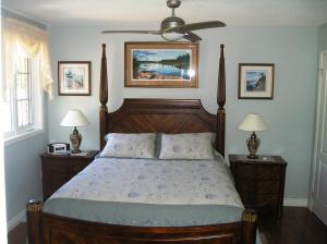 a bedroom with a wooden bed with two night stands at Tucked Inn the Harbour B&B in Victoria Harbour