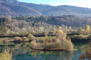 a lake in the middle of a valley with trees at La Grange in Le Noyer
