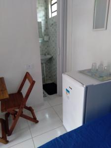 a kitchen with a chair and a refrigerator at SUITES E CHALES PRIVADOS Rock's&Rose's home in Camburi +199 photos
