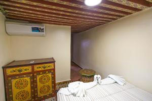 ein Schlafzimmer mit einem Bett, einer Kommode und einer Decke in der Unterkunft Dar El Ouedghiri in Fès