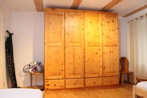 einen großen Holzschrank in einem Schlafzimmer mit einem Bett in der Unterkunft Alt-Gailingen in Gailingen