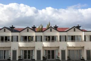 a large white building with a red roof at Cornwall Motor Lodge in Palmerston North