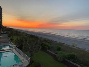 een uitzicht op het strand bij zonsondergang vanuit een resort bij Jade Tree Cove by Capital Vacations in Myrtle Beach